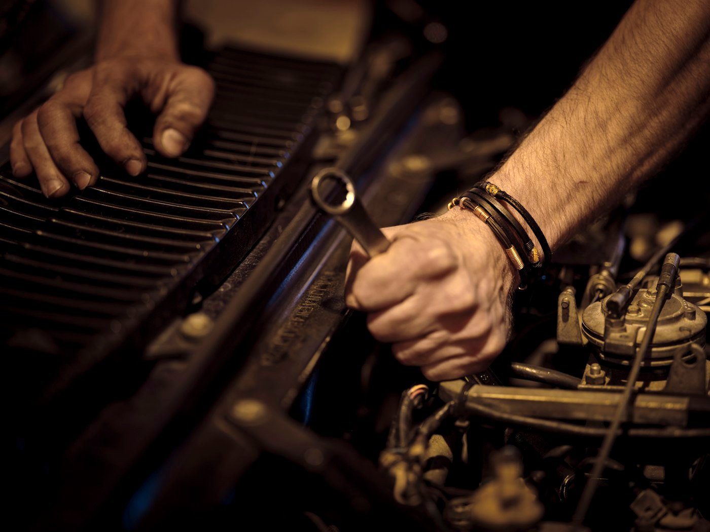 Mains d'un technicien serrant un boulon avec une clé plate sur un moteur
